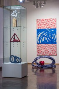 Left in the display case: The Significance of Shape – Star Tetrahedron 2017 Tetraheart. 2018. 27 x 32 x 32cm Fabric and thread Flow. 2018. 25 x 40 x 40cm Pipe and fabric Right: The Lotus Experiment 2018 48 x 107 x 97cm Pipe, fabric and thread with Henning Eichinger, Red/Blue 2011